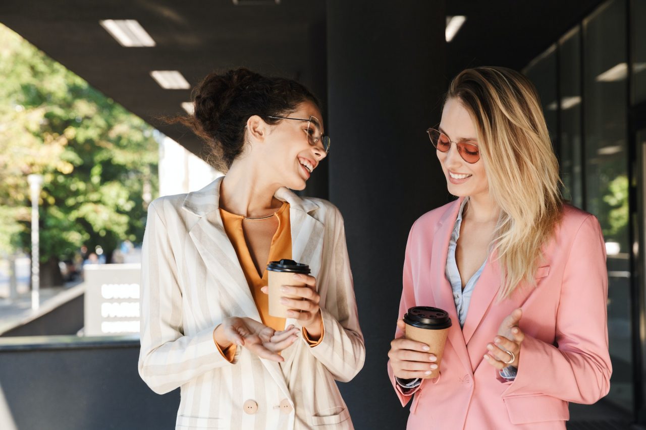 two beautiful young businesswomen walking outdoors